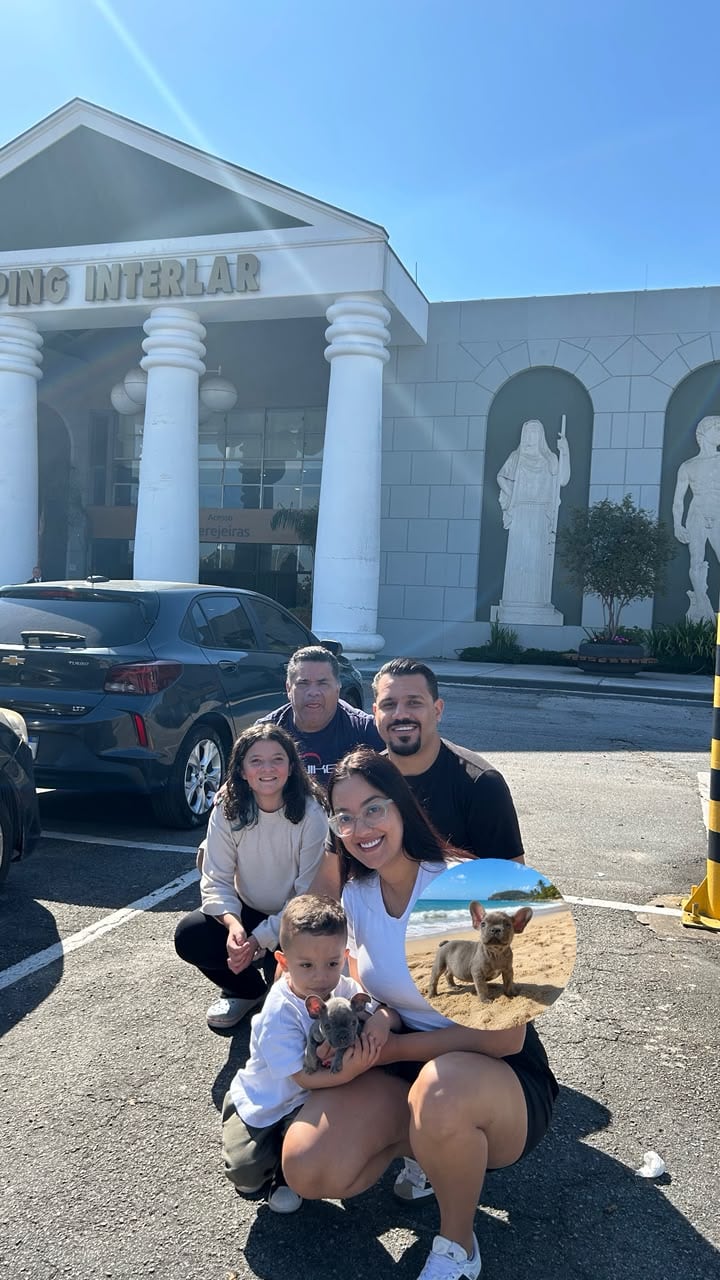 Família reunida com um menino segurando o novo filhote de Bulldog Francês